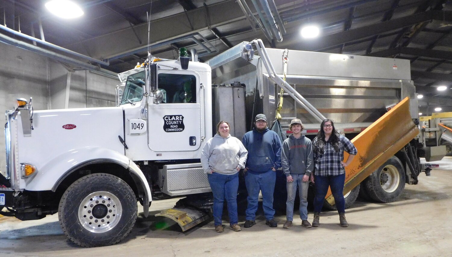The next generation of eager Clare County Road Commission professionals stand alongside one of the plow trucks synonymous with the winter season. Pictured, from left, are Ashlyn Kohn, Perry Davis, Chase Swartzmiller and Victoria Humphrey.